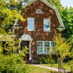 Charming brick house with lush greenery in suburban Québec, Canada.